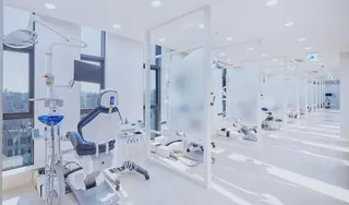 Dental chairs separated by partitions in the open treatment area