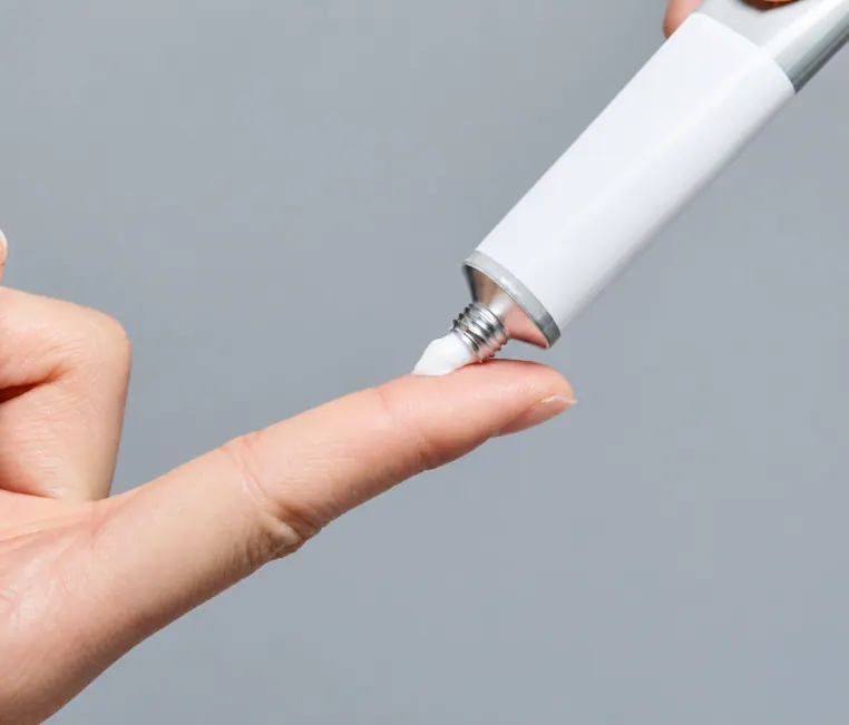 Anesthetic cream being squeezed onto a fingertip
